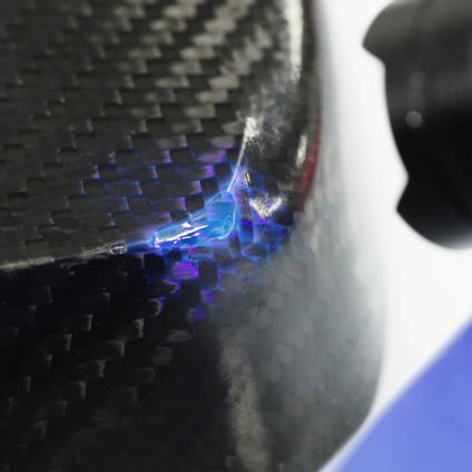 Using a UV torch to cure 130UV adhesive to repair a void on a carbon fibre part